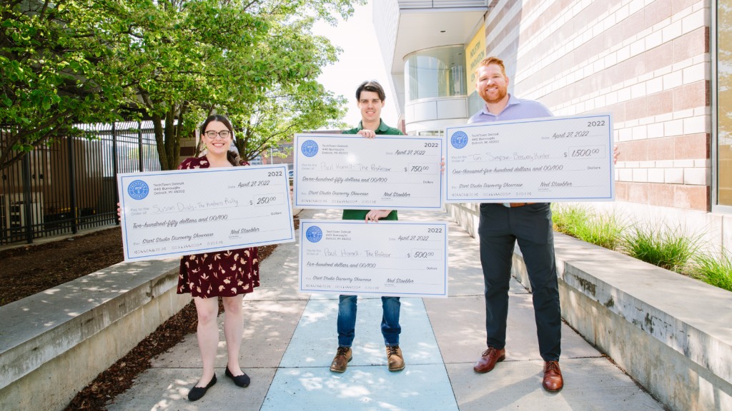 Photo of four TechTown Start Studio Discovery Showcase winners holding winner checks