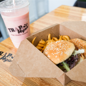 A pink smoothie and burger and fries from Trap Vegan