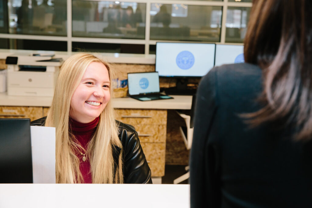 A TechTown Community Ambassador talks with a coworking member at the front desk