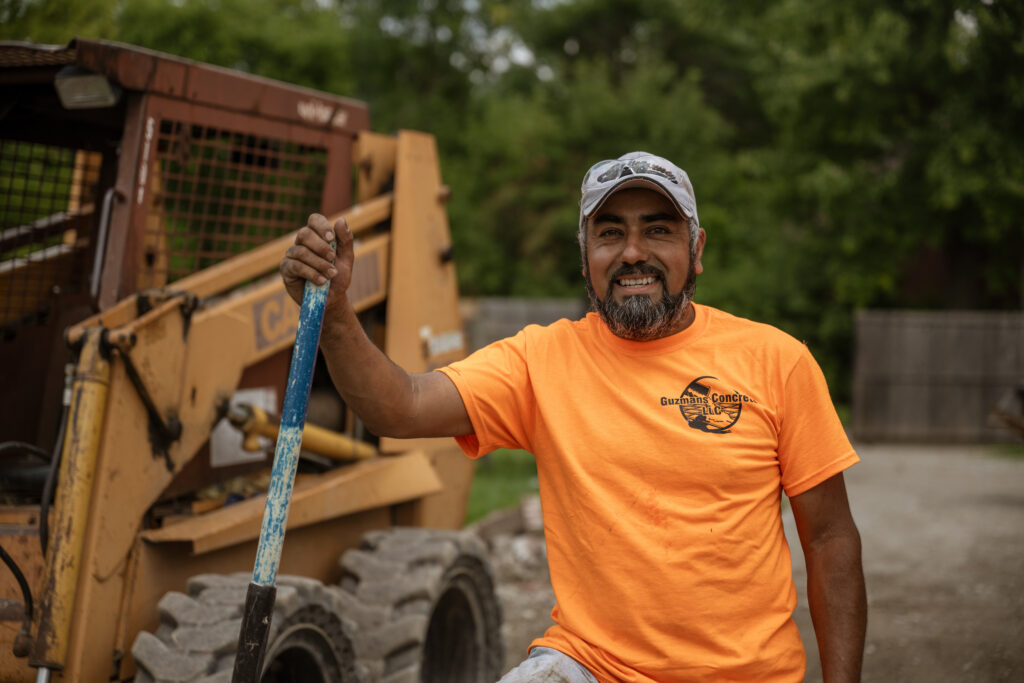 Salvador Guzman stands with a shovel in hand at a worksite
