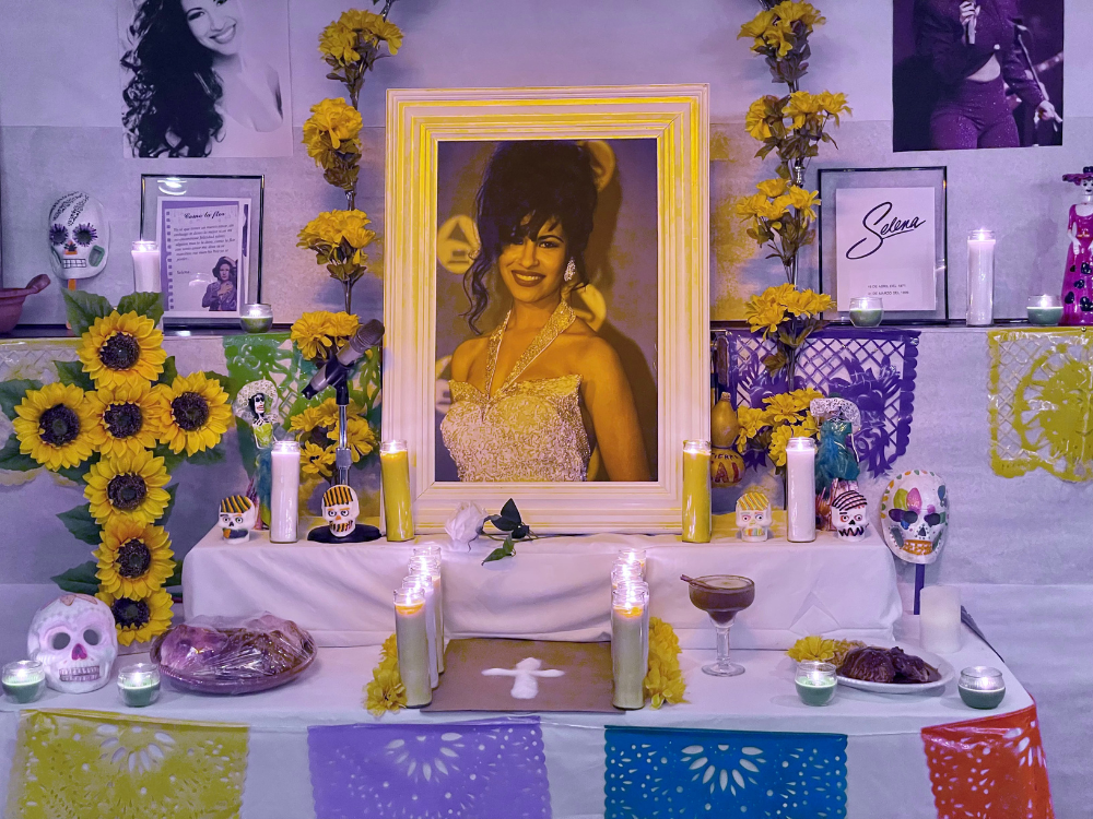 A display of ofrendas for Day of the Dead at La Terraza. The display includes photos of the late Mexican American singer, Selena. candles, flowers and food