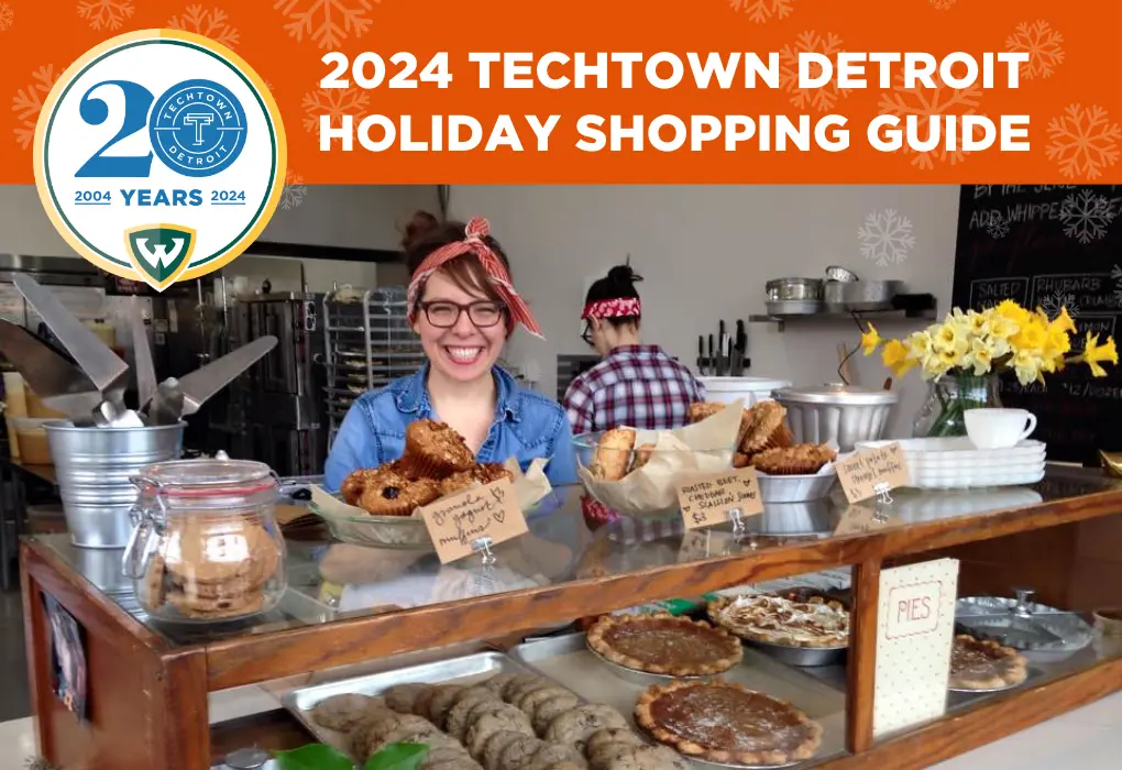 A graphic that reads "2024 TechTown Detroit Holiday Shopping Guide." Under this copy is a photo of Lisa Ludwinski, chef and owner of Sister smiling and standing behind a display of pastries and other baked goods at her bakery