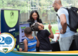 A photo of tech founder Ernestine Lyons, creator of Linglobal, stands behind a table display for her startup. In front of it are two kids and adult looking at the items on the table