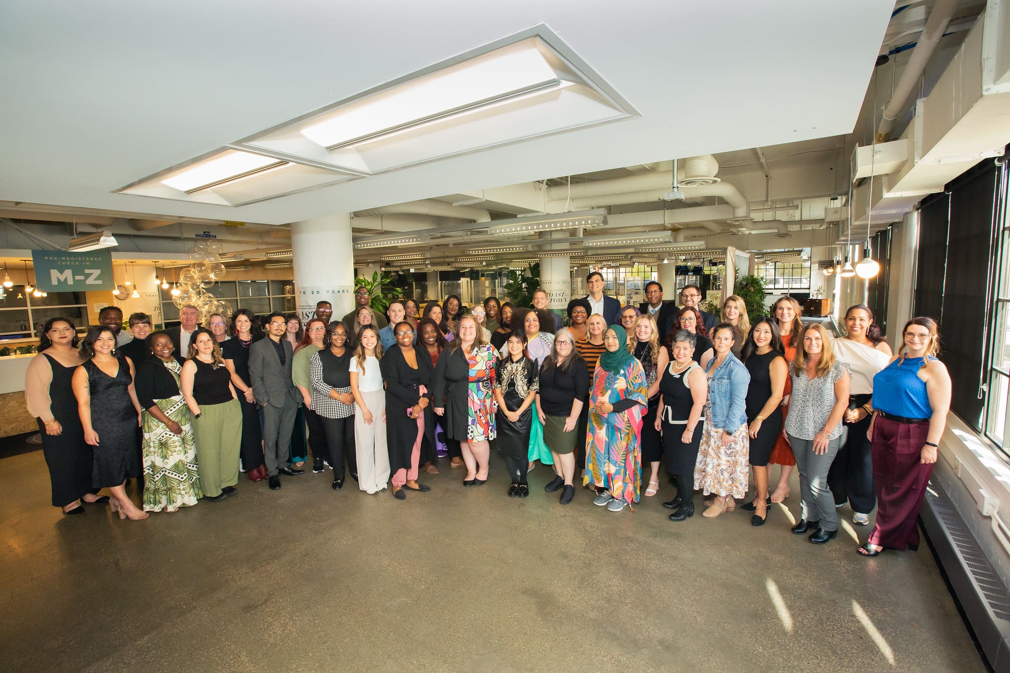 An image of a large group of people standing and smiling in the TechTown space