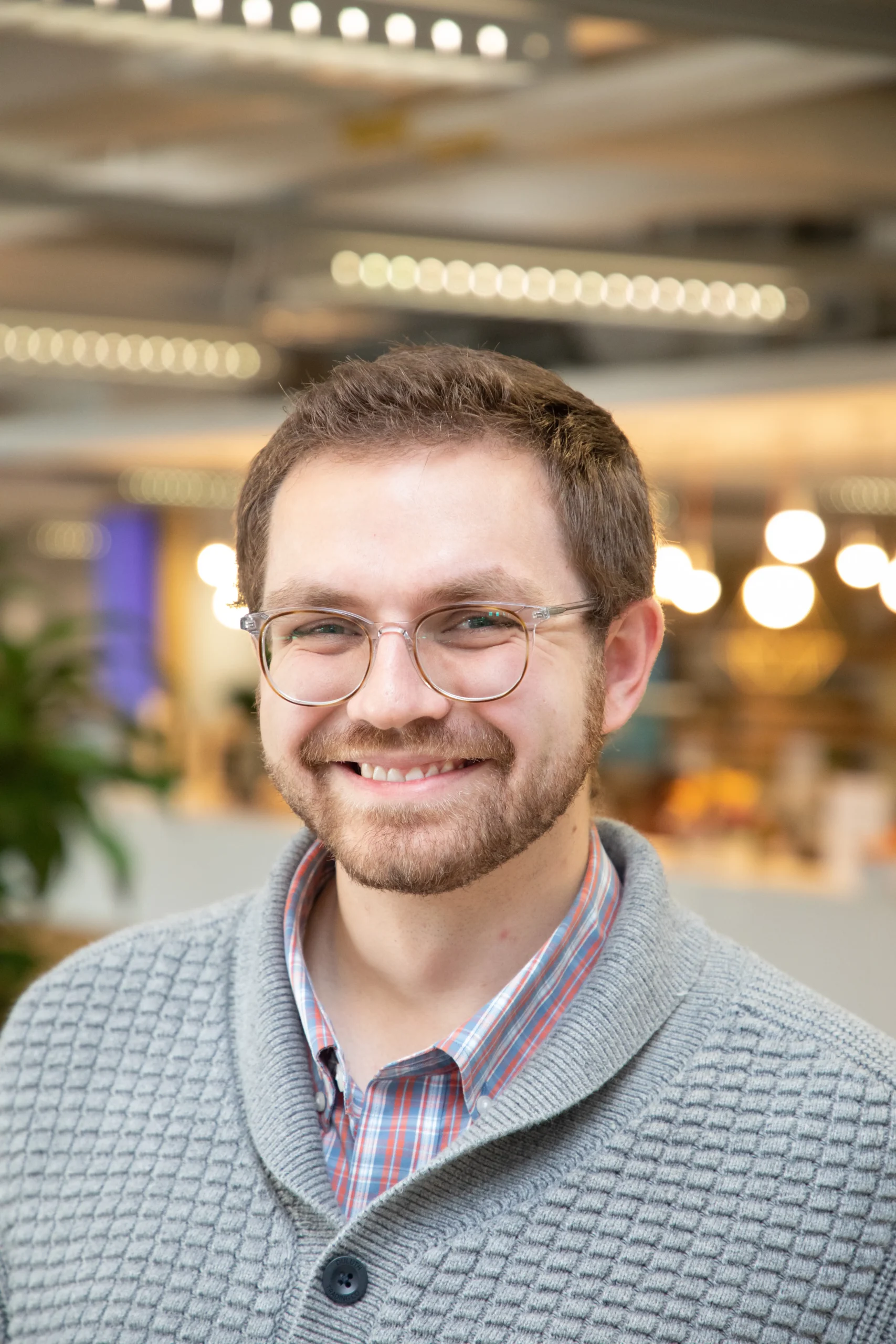 David Behrens con jersey gris claro y gafas.