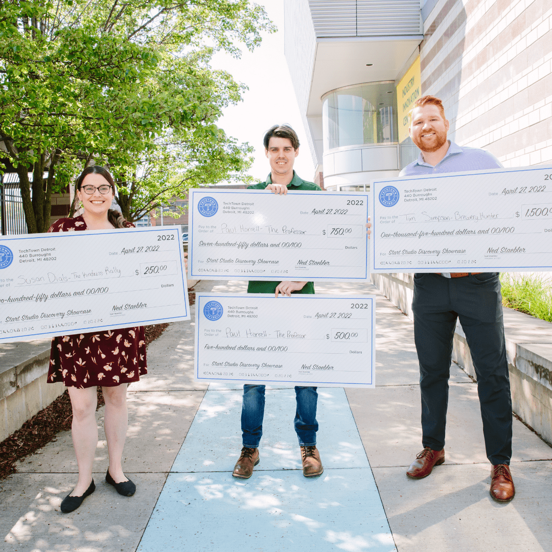 Photo of four TechTown Start Studio Discovery Showcase winners holding winner checks