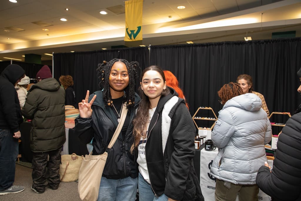 Two people smile and pose for a photograph at the 2023 Winter Art and Retail Market